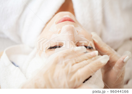 Cheerful woman with a towel on her head face mask clean skin 96044166