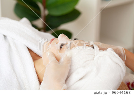 Cheerful woman with a towel on her head face mask clean skin 96044168
