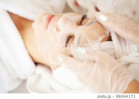 Cheerful woman with a towel on her head face mask clean skin 96044171