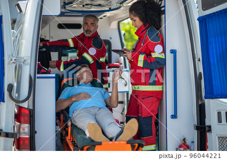 Ambulance staff listening to the sick man complaints 96044221