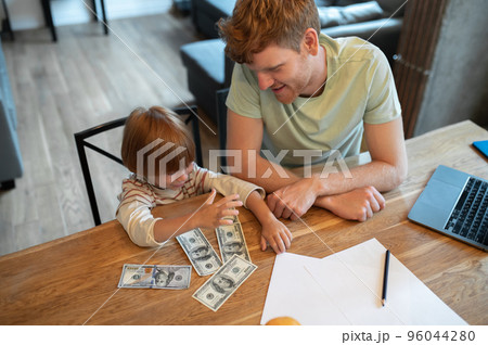 Dad explaining his son the importance of financial literacy 96044280