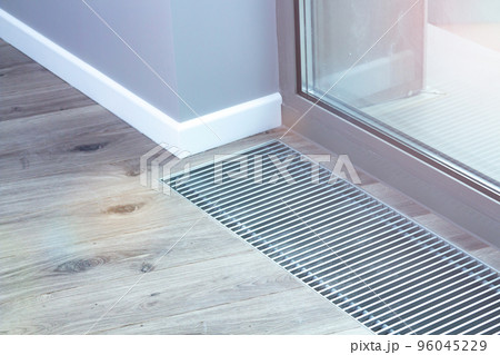 Floor convector heating metal grate built into the floor next to the window. Floor convector heating metal grate built into the floor next to the window. 96045229