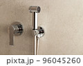 Stainless steel manual bidet sprayer located on the toilet wall 96045260