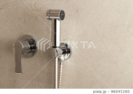 Stainless steel manual bidet sprayer located on the toilet wall 96045260