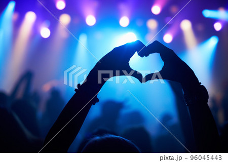 Enjoying every song the band plays. Cropped shot of a crowd at a concert. 96045443