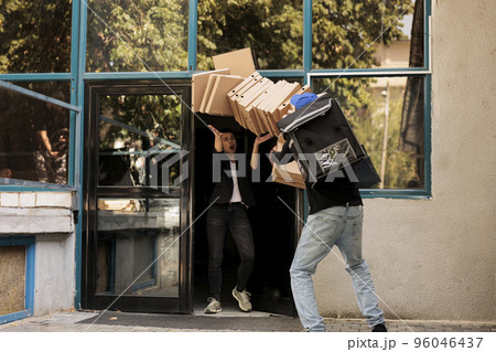 Deliveryman dropping pizza, customer catching boxes pile, clumsy courier carrying food order outdoors. Bad delivery service, client watching fastfood packages huge stack falling 96046437