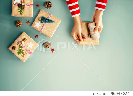 Person making Christmas gift boxes 96047024