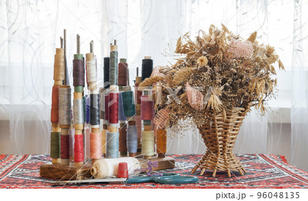 Sewing multicolored threads of soft pastel vintage colors on spools. Sewing tailor related accessories. 96048135