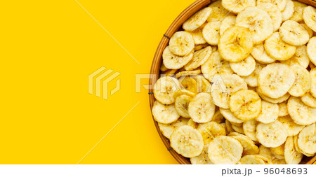 Banana slice chips on yellow background. 96048693