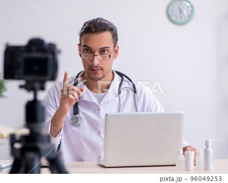 Young male doctor recording video for his blog 96049253