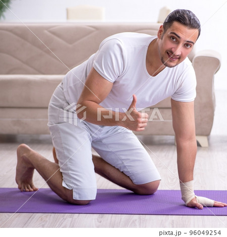 Hand injured man doing exercises at home 96049254
