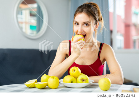 Portrait of a happy woman with apples at the table in room at home. Diet and weight loss concept 96052243
