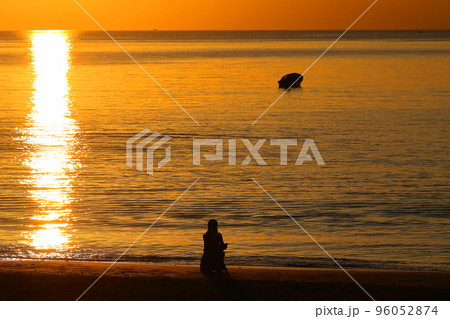 秋の夕暮れの逗子海岸、夕焼けに染まる海を眺める女性 秋の夕暮れの逗子海岸、夕焼けに染まる海を眺める女性 96052874