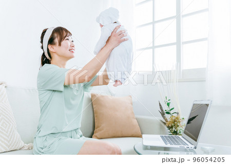 テレワークをしながら赤ちゃんをあやす女性 96054205