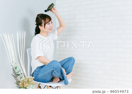 髪の毛にヘアケア用品・スタイリング剤をつける日本人女性 96054973