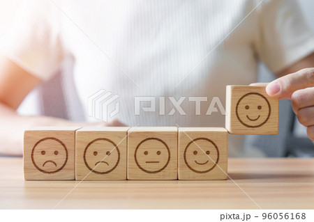 Hand choosing smile face from Emotion block.  customer review, good experience, positive feedback, satisfaction, survey, rating service, assessment, mood, world mental health day concept 96056168