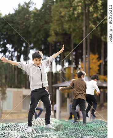 トランポリンのような遊具で元気に遊ぶ小学生男子 トランポリンのような遊具で元気に遊ぶ小学生男子 96056211