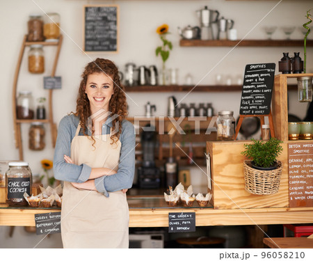 Can I help you. Portrait of an attractive young barista starting at a cafe counter. 96058210
