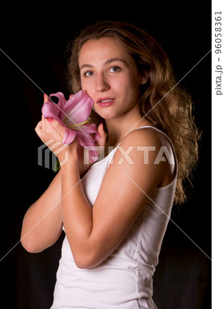 Beauty face of the young beautiful woman with flower. Female touching skin. 96058361