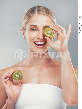 Happy studio portrait, woman with kiwi for skincare wellness, health and beauty by grey wall. Cosmetics model, girl with smile, fruit and self care for healthy facial, skin or vitamins by background 96058520