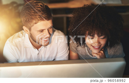 Were making good progress. Shot of colleagues working late at the office. 96058992