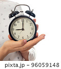 Woman hands holding black alarm clock 96059148