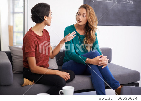 Theyre working together on an exciting project. Shot of two female professionals having a discussion in an informal office setting. 96059654