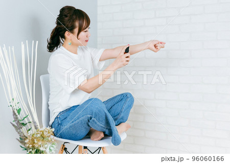 腕にスプレーする笑顔の日本人女性 腕にスプレーする笑顔の日本人女性 96060166