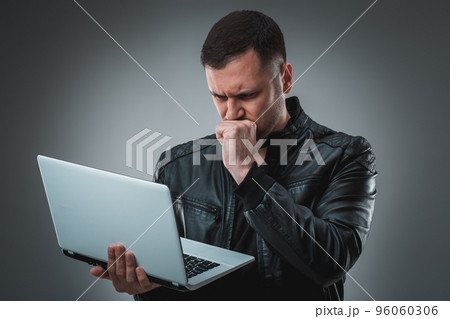 Portrait of young handsome man using laptop, wearing black leather jacket. 96060306