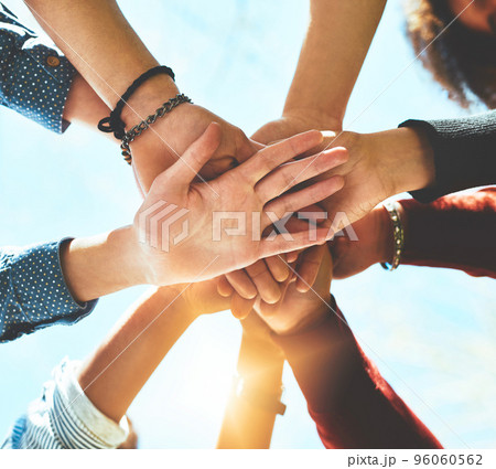 In it to win it. High angle shot of an unrecognizable group of college friends standing outside with their hands in a huddle. In it to win it. High angle shot of an unrecognizable group of college friends standing outside with their hands in a huddle. 96060562