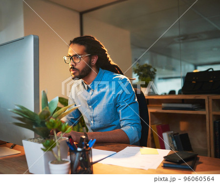 You need a tireless work ethnic to reach success. Cropped shot of a young designer working late on a computer in an office. 96060564