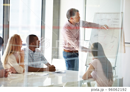 Motivating his staff through effective training. Shot of a group of business colleagues in a boardroom meeting. Motivating his staff through effective training. Shot of a group of business colleagues in a boardroom meeting. 96062192