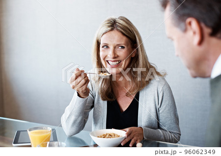 Catching up at breakfast. Shot of a mature couple eating breakfast in their kitchen. 96062349