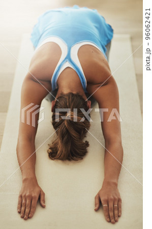 Fitness is a lifestyle. High angle shot of a young woman practicing yoga at home. Fitness is a lifestyle. High angle shot of a young woman practicing yoga at home. 96062421