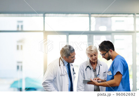 Smart doctors use smart apps. Shot of a team of doctors using a digital tablet together in a hospital. Smart doctors use smart apps. Shot of a team of doctors using a digital tablet together in a hospital. 96062692
