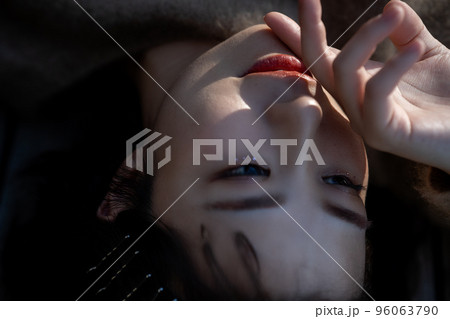 日差しの中寝転ぶ若い女性のアップ 96063790