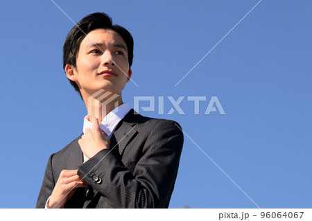 きゅっとネクタイを締めて未来に向かう若者のイメージ 96064067