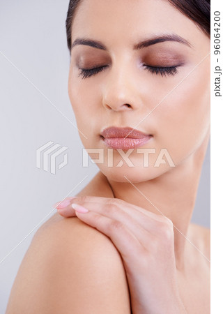 Beauty personified. Shot of a beautiful young woman posing against a gray background. Beauty personified. Shot of a beautiful young woman posing against a gray background. 96064200