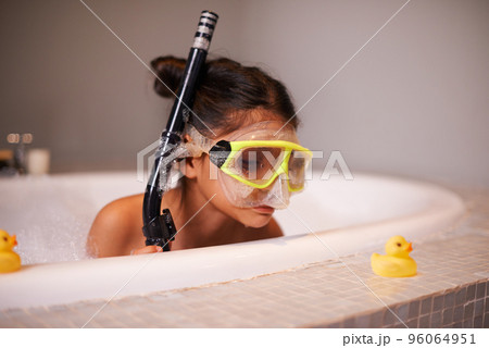 Like a duck to water. Shot of a cute little girl wearing snorkeling gear in the bath. 96064951