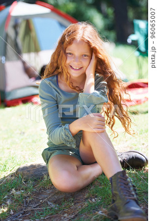 Loving summer camp. Shot of a young girl sitting in front of her campsite. Loving summer camp. Shot of a young girl sitting in front of her campsite. 96065007