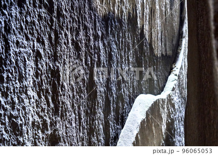 Sandstone slab on a vertical cleft surface with arched break edge, abstract graphic impression. Sandstone slab on a vertical cleft surface with arched break edge, abstract graphic impression. 96065053
