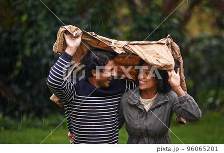 Here comes the rain. Cropped shot of an affectionate young couple trying to escape the rain. 96065201