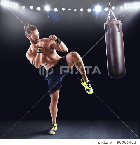 Man is training with the punching bag 96065423