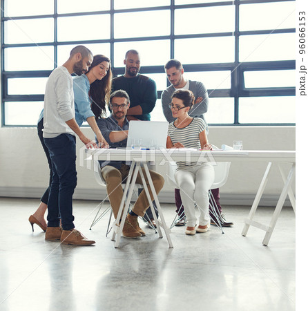 Sharing his expertise with the team. Shot of a group of coworkers having a meeting in an open plan office. Sharing his expertise with the team. Shot of a group of coworkers having a meeting in an open plan office. 96066153