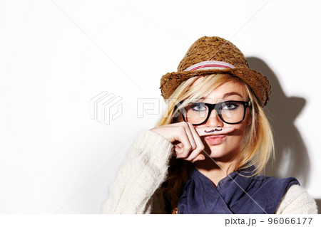 Call me mister. Closeup of a young woman holding her finger under her nose with a moustache drawn on it. Call me mister. Closeup of a young woman holding her finger under her nose with a moustache drawn on it. 96066177