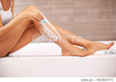 Soft and silky. Cropped view of a woman shaving her legs. 96066475