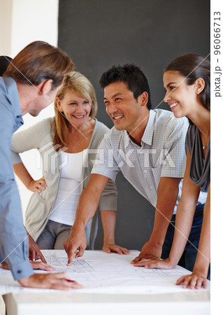This is where well get started tomorrow. Shot of a group of coworkers looking over a set of plans. 96066713