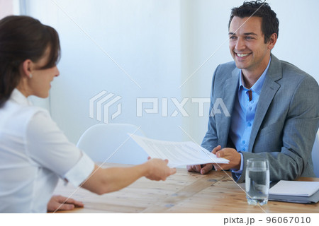 Handing him her resume. A pretty young woman handing her resume to a prospective employer at a job interview. Handing him her resume. A pretty young woman handing her resume to a prospective employer at a job interview. 96067010