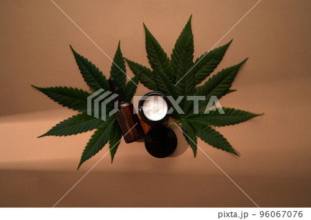 A mock-up for your face and body care cosmetic product based on medical cannabis. Serum or oil and cream on a light background. Copy space. Flat lay. Health and wellbeing concept. A mock-up for your face and body care cosmetic product based on medical cannabis. Serum or oil and cream on a light background. Copy space. Flat lay. Health and wellbeing concept. 96067076