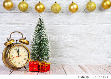 Decorative christmas tree, gift boxes and alarm clock on white wooden background. 96067494